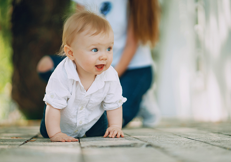 little beautiful boy in a white shirt playing in the park
