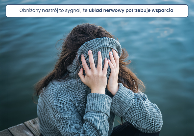 A woman hid her face in a sweater while sitting by the sea, the concept of mental health and mood.